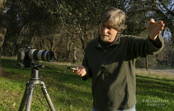 To shade the lens without getting your hand in the picture, step around in front of the camera