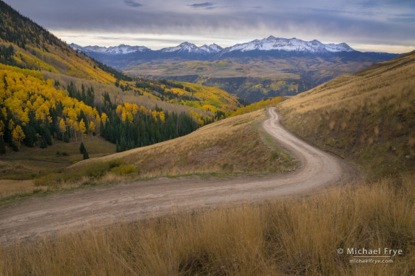 Backcountry road in autumn with the San Miguel Range in the distance, Uncompahgre NF, CO, USA