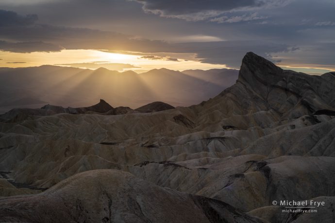 Sun setting behind Manly Beacon, Death Valley, with the Adobe Landscape profile, Adobe Lightroom Classic CC. There's a bit more definition in the clouds near the sun and the sunbeams, plus a little more shadow detail.