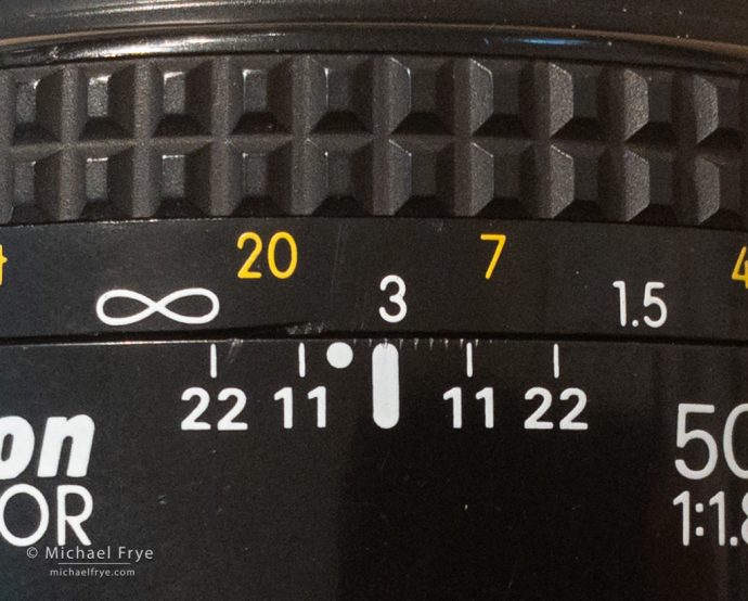 If the closest object to the camera is 7 feet away, and the farthest object is 20 feet away, then I focus halfway between those two marks on the lens.