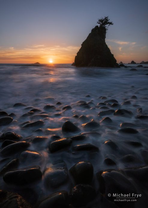 Sea stack and boulders at sunset, California coast, USA