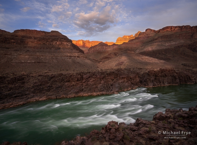 Sun setting on cliffs above a rapid in the Colorado River, Grand Canyon NP, AZ, USA