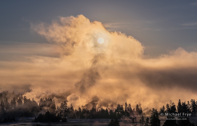 Sun rising through fog and steam, Yellowstone NP, WY, USA