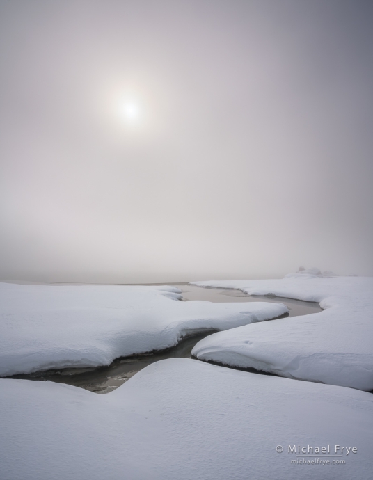 Sun breaking through fog along the shore of Mono Lake, CA, USA