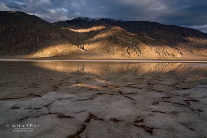 Dappled light and reflections in flooded salt flats, Death Valley NP, CA, USA
