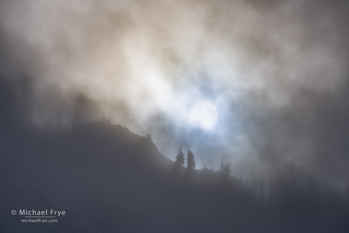 Sun breaking through mist above the south rim of Yosemite Valley, Yosemite NP, CA, USA